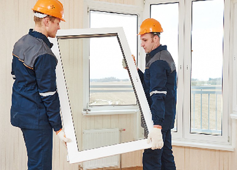 Two installers fitting a double-glazed window unit
